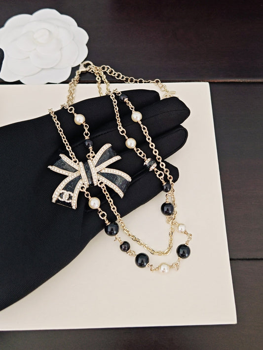 Bow Pendant Necklace in Gold-Tone – Black Detail main product view