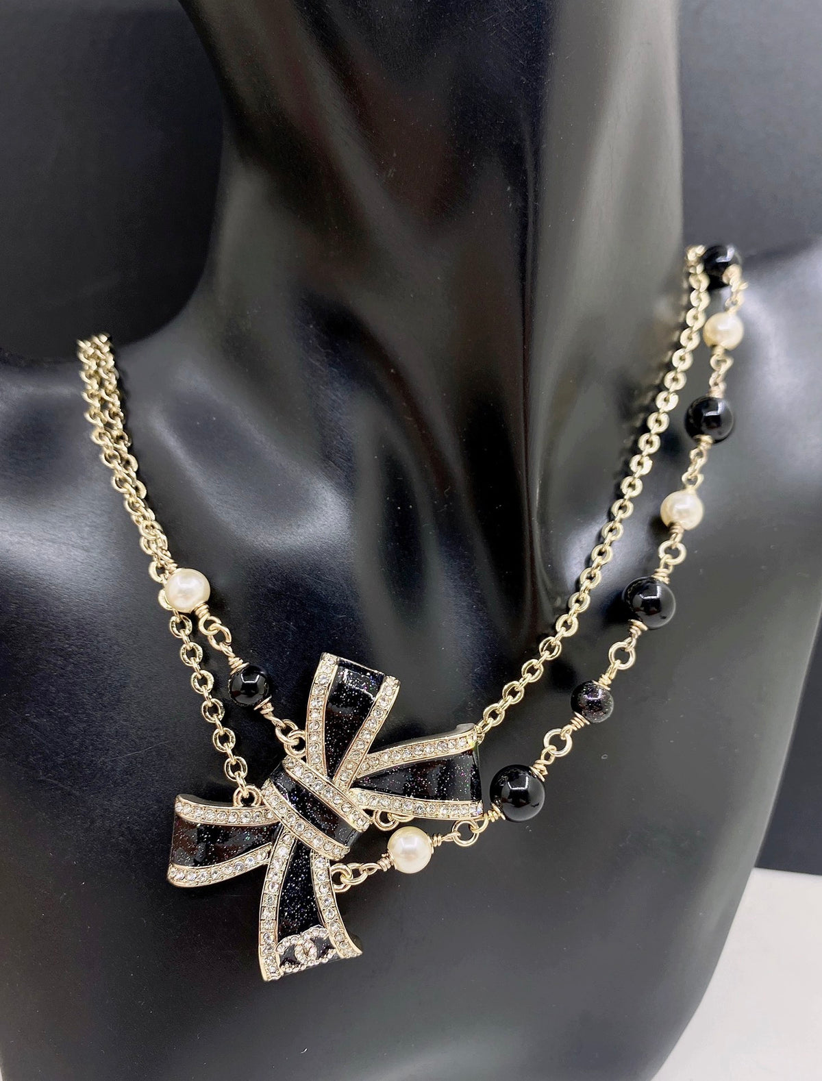 Bow Pendant Necklace in Gold-Tone – Black Detail front product view