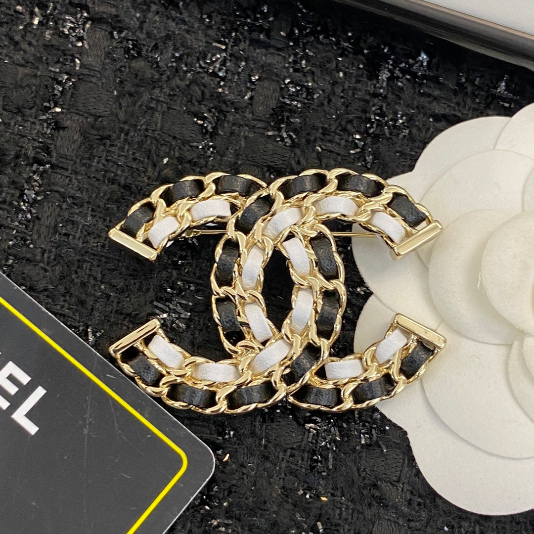 Signature Emblem Brooch in Polished Metal-Tone – Black Detail front product view