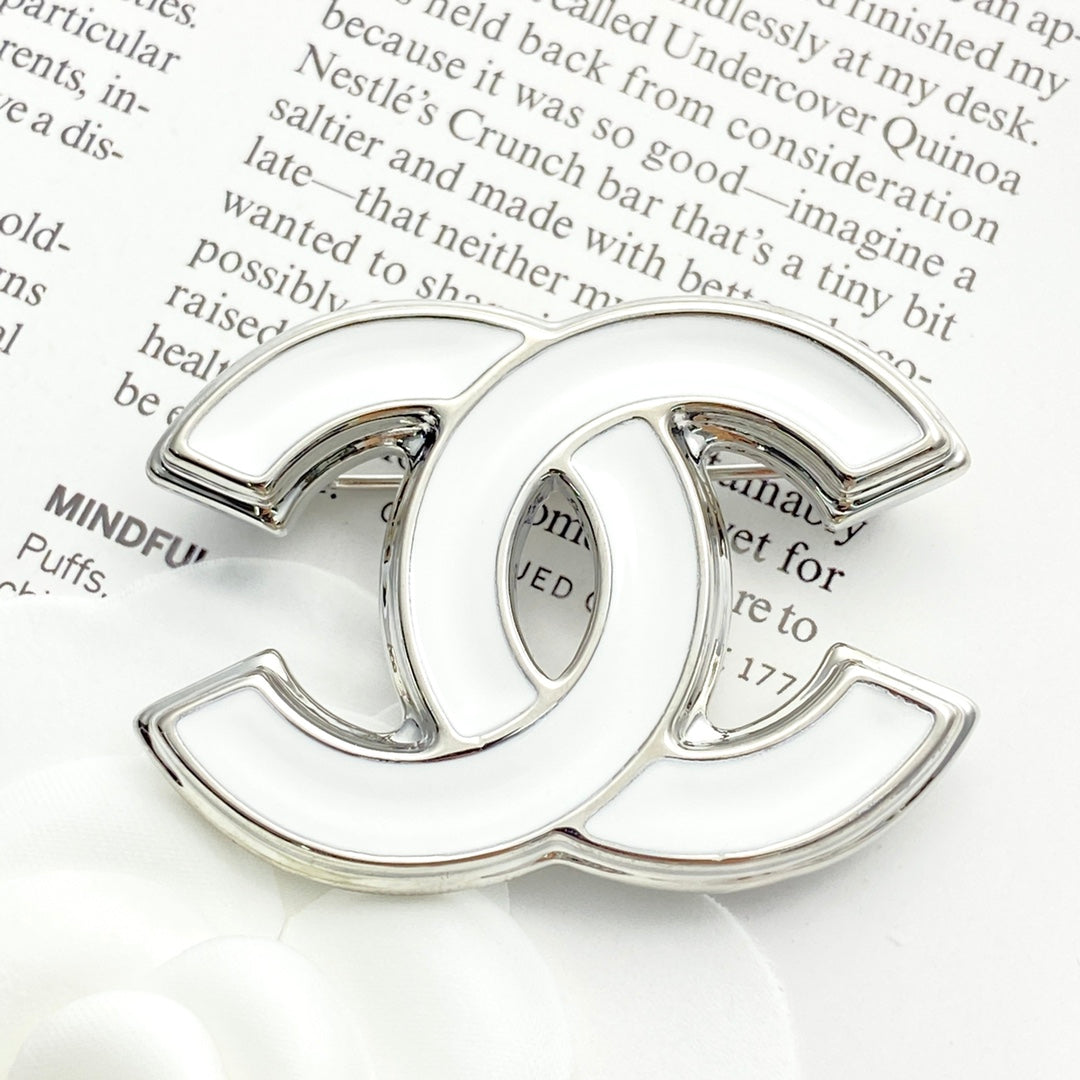 Double-C Emblem Brooch in Polished Metal-Tone – White Detail detail view