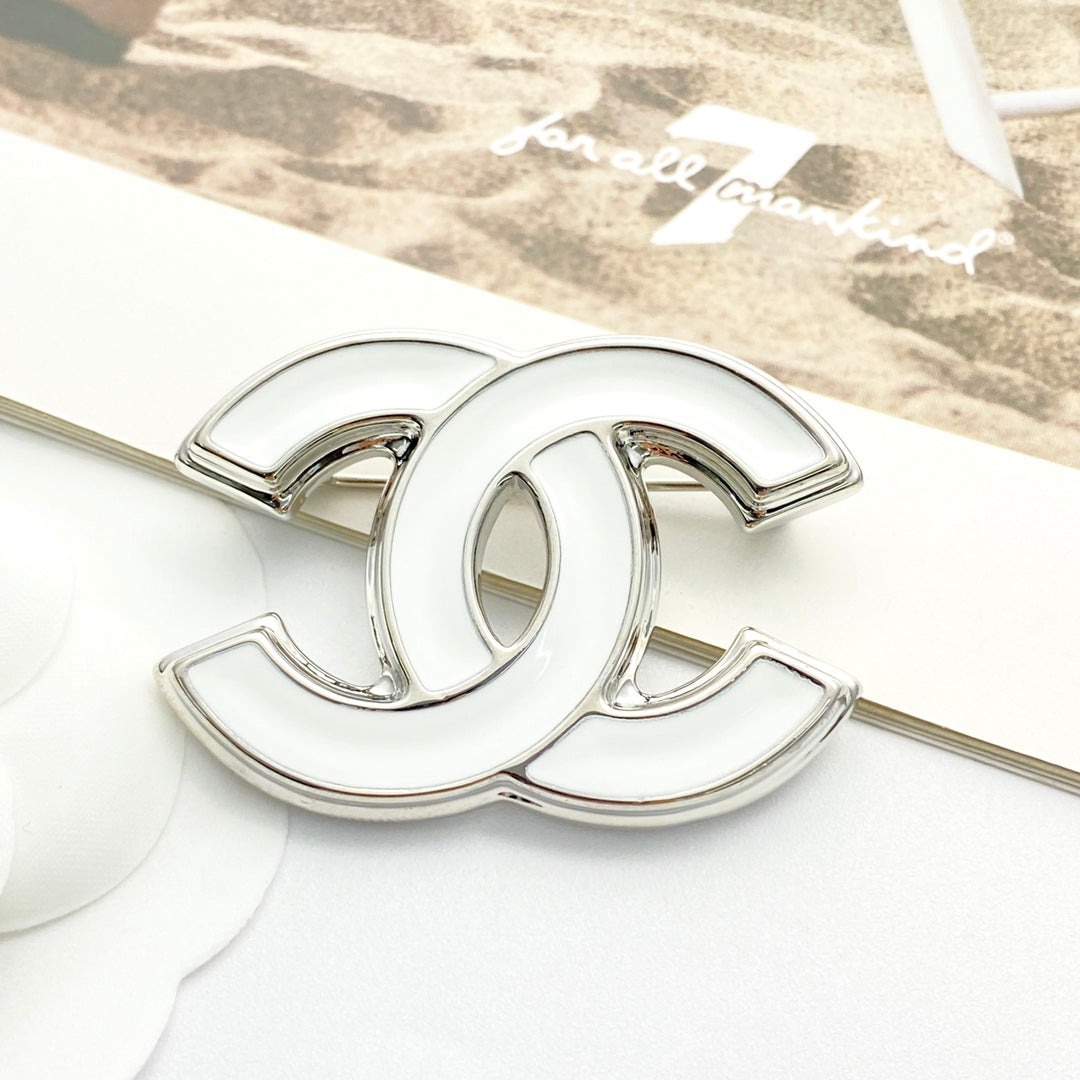Double-C Emblem Brooch in Polished Metal-Tone – White Detail front product view