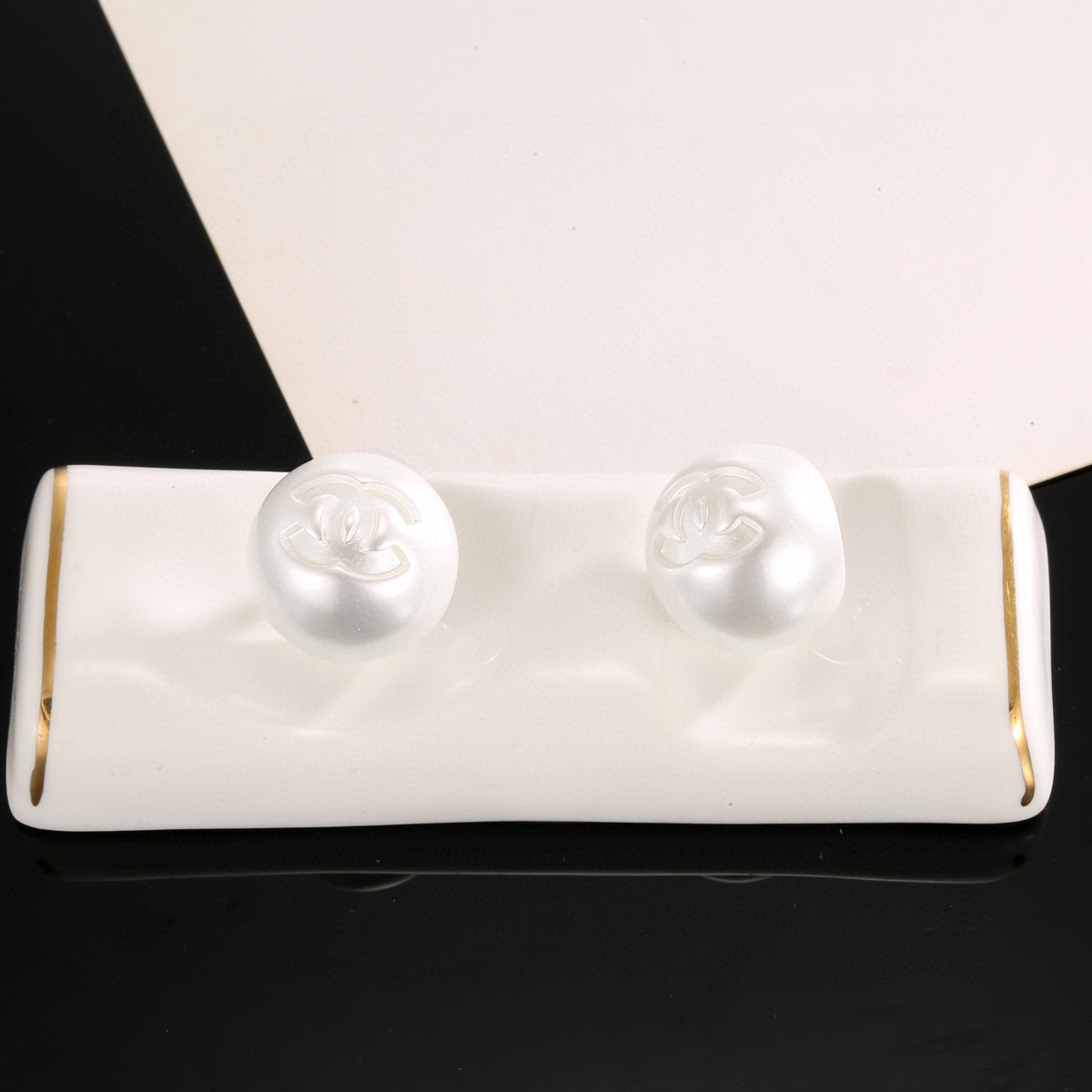 Double-C Emblem Stud Earrings in Polished Metal-Tone – White Detail – Design 003 close-up detail