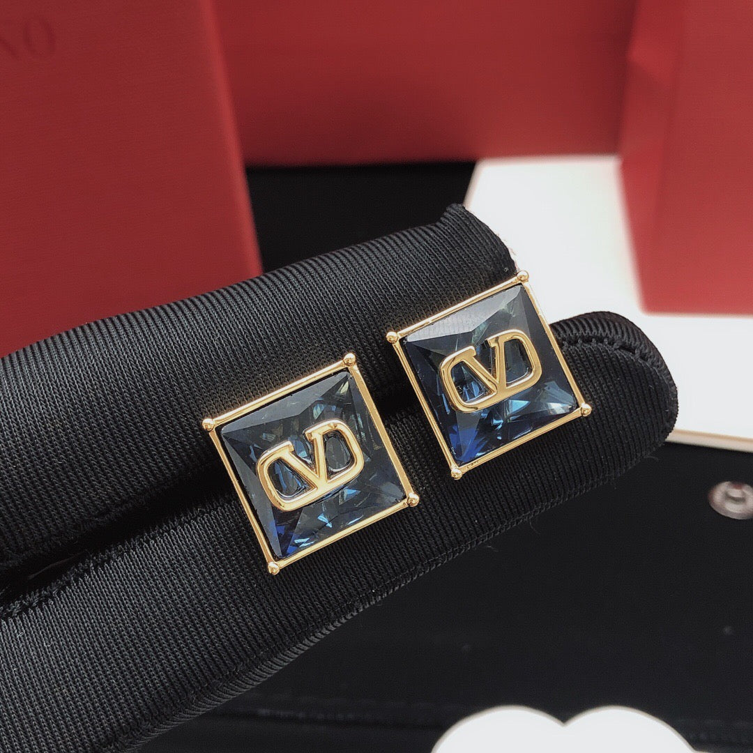 Signature Emblem Stud Earrings in Polished Metal-Tone – Red close-up view