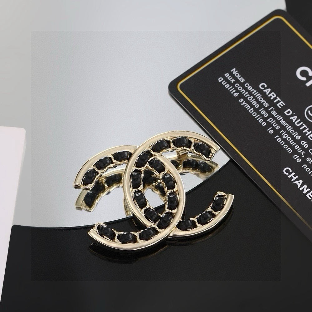 Double-C Emblem Brooch in Polished Metal-Tone – Black Detail – Design 002 close-up detail
