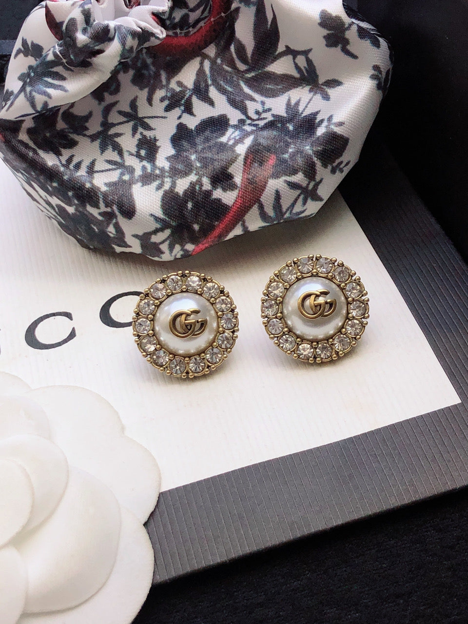 Letter Emblem Stud Earrings in Polished Metal-Tone close-up detail